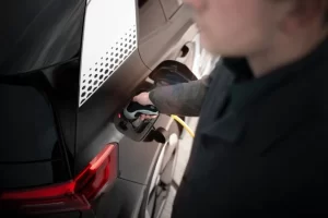 man charging ev using public charging station